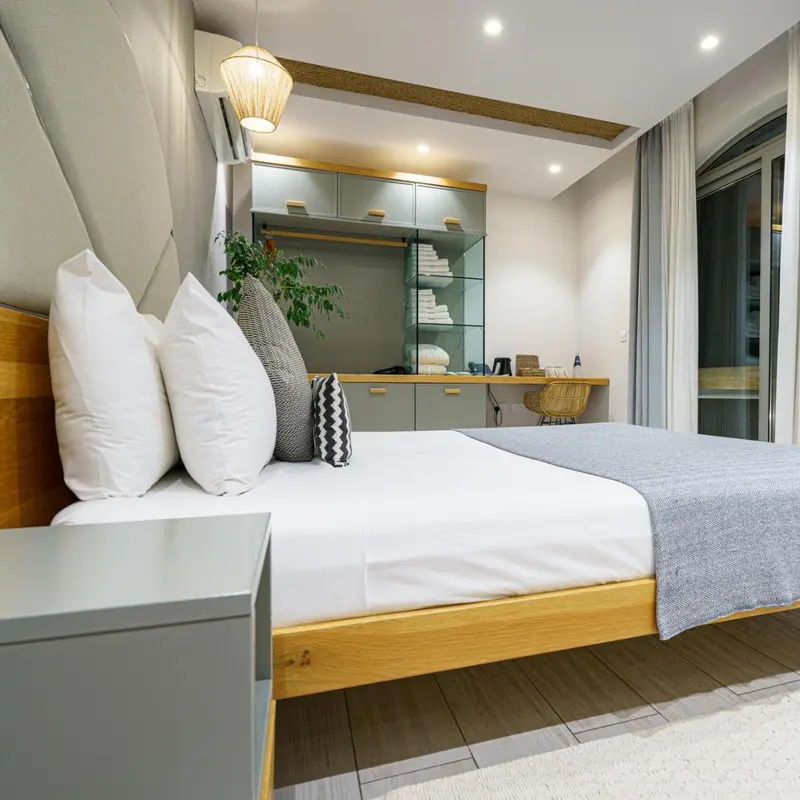 Une chambre lumineuse avec un grand lit et un espace bureau intégré.