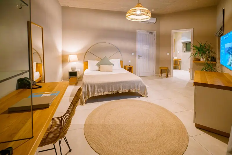 Une chambre lumineuse avec un grand lit et un espace bureau.