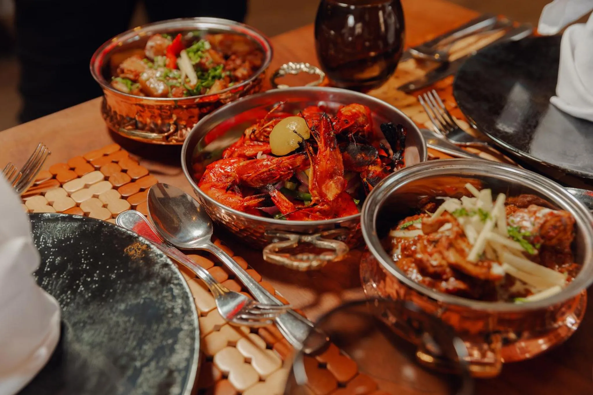 Assiettes de plats épicés servis sur une table en bois.