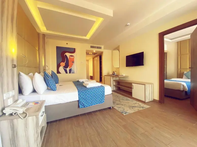 Chambre lumineuse avec un grand lit et un espace détente.