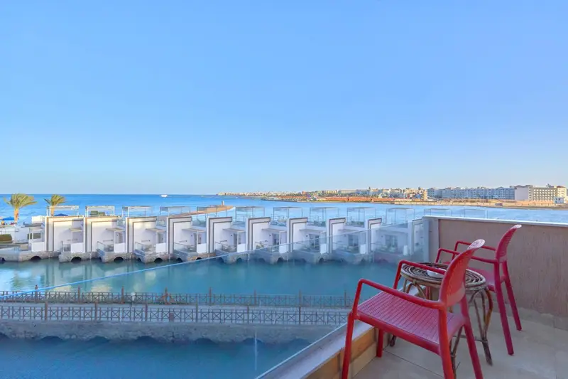 Terrasse avec mobilier d'extérieur donnant sur une piscine et la mer.