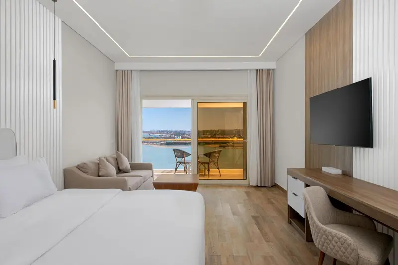 Une chambre lumineuse avec un canapé et une vue sur la mer.