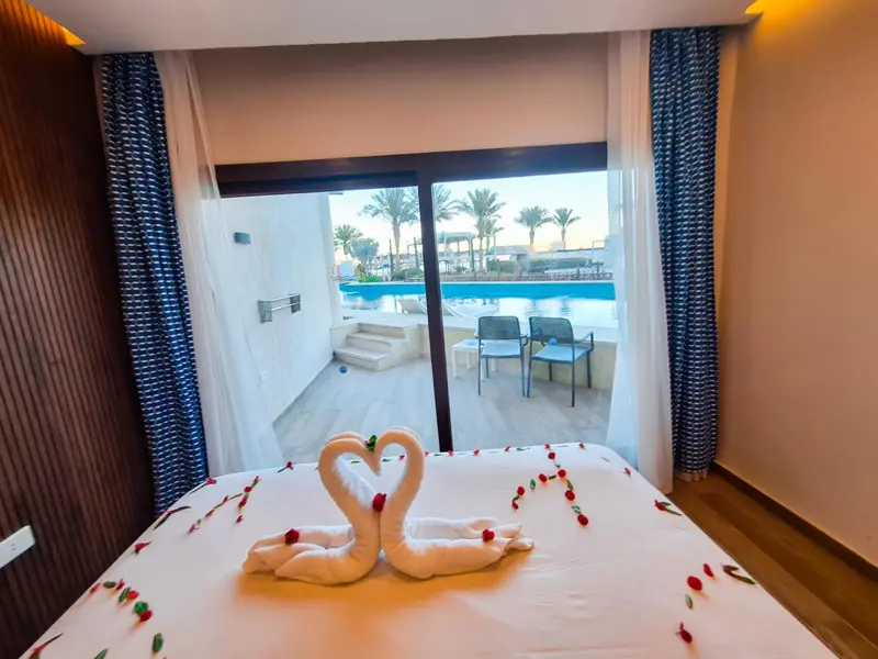 Une chambre d'hôtel avec vue sur une piscine et une plage.