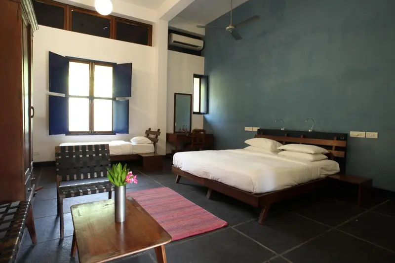 Une chambre lumineuse avec deux lits et un coin salon.