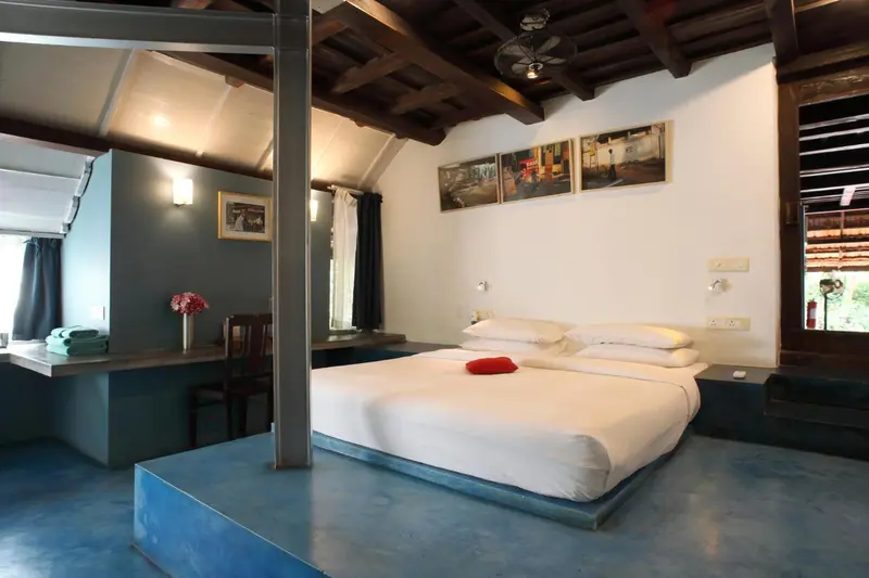 Une chambre lumineuse avec un lit confortable et un coin repos.