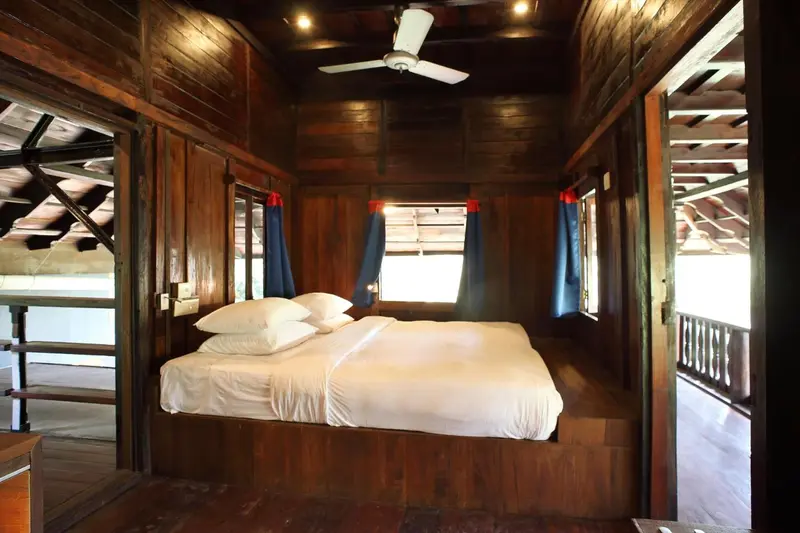 Une chambre avec un lit double et un ventilateur au plafond.