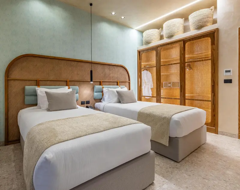 Chambre avec deux lits simples et décoration en bois.