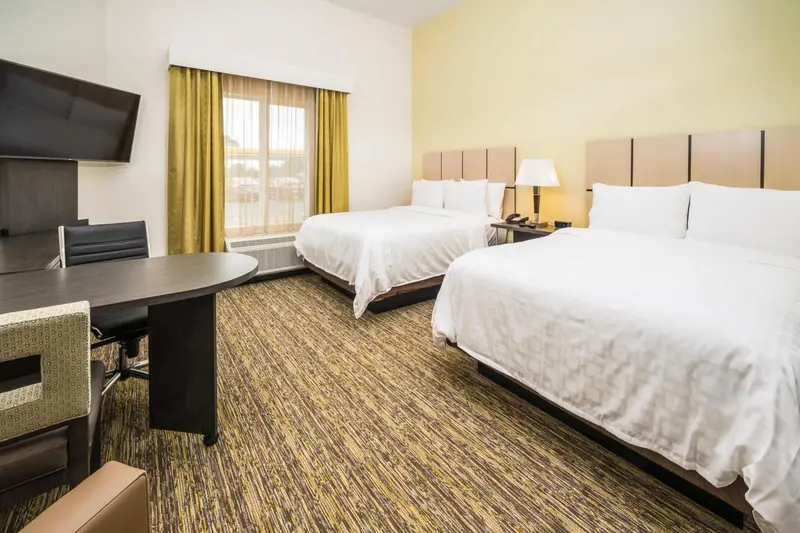 Une chambre d'hôtel lumineuse avec deux lits et un espace de travail.