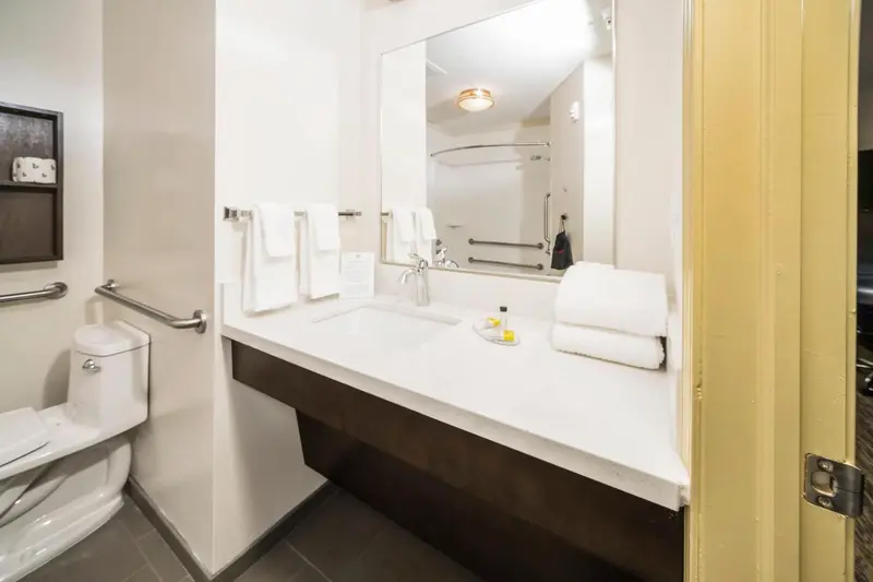 Une salle de bain moderne avec lavabo, miroir et douche.