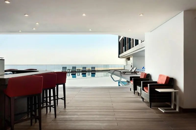 Terrasse avec bar et mobilier de détente face à la mer.