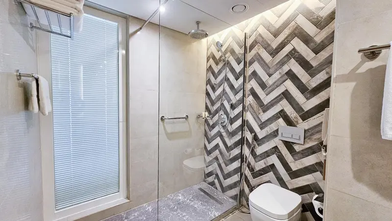 Une douche à l'italienne moderne avec un mur en mosaïque.