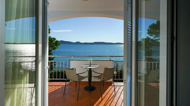 Une terrasse ensoleillée offre une vue sur la mer et les collines environnantes.