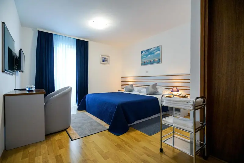 Une chambre lumineuse avec un grand lit et un coin repos.
