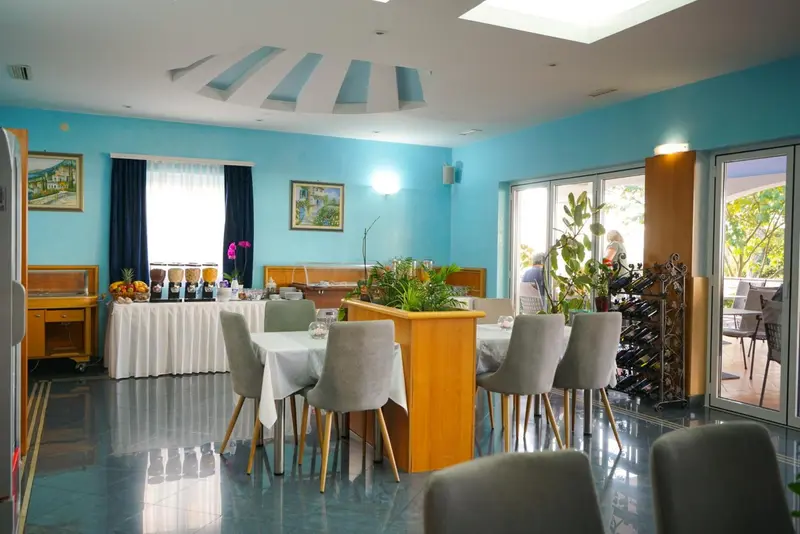 Une salle lumineuse avec un buffet et des tables pour le petit-déjeuner.