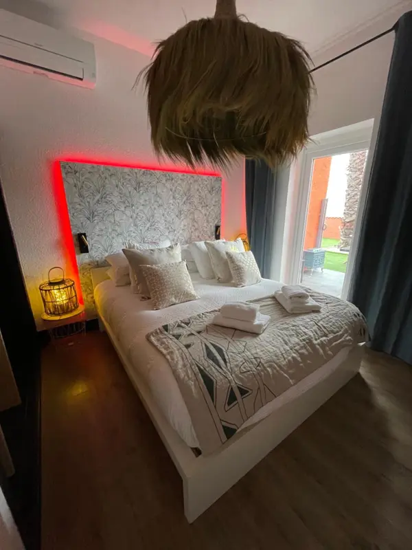 Une chambre avec un grand lit recouvert d'une couette et de plusieurs oreillers.