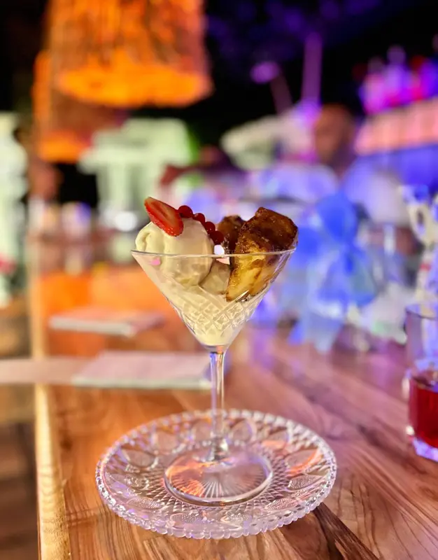 Un dessert glacé à la coupe est présenté sur une table en bois.