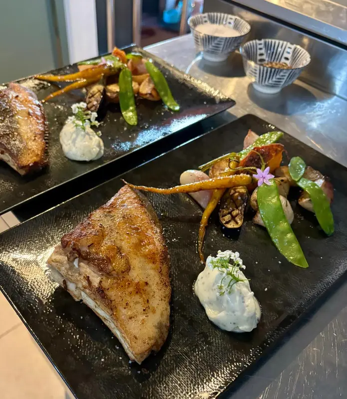 Assiettes de poisson et de légumes présentées avec soin.