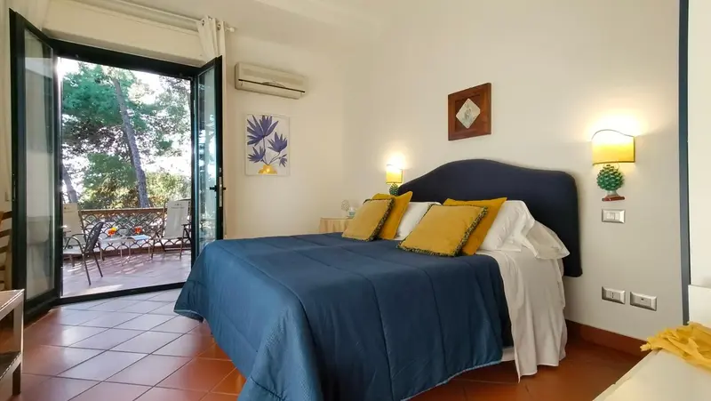 Une chambre lumineuse avec un grand lit et un accès à une terrasse.