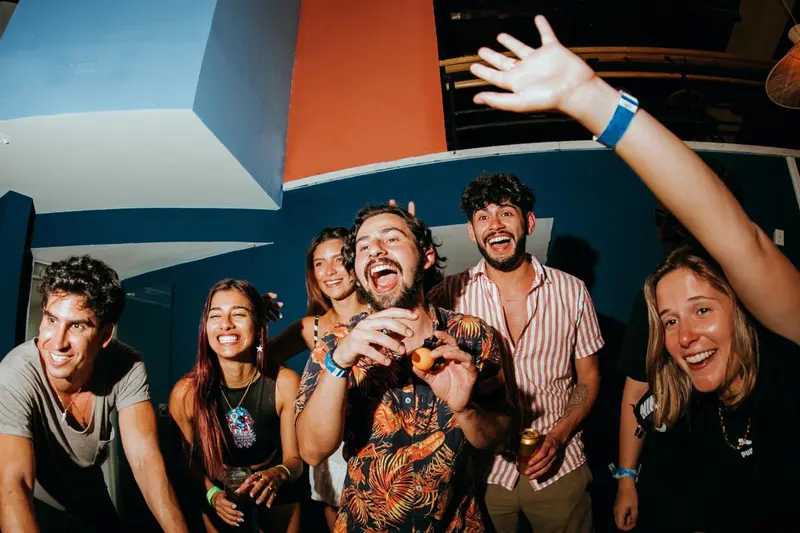 Groupe de personnes souriantes et joyeuses dans un espace intérieur coloré.