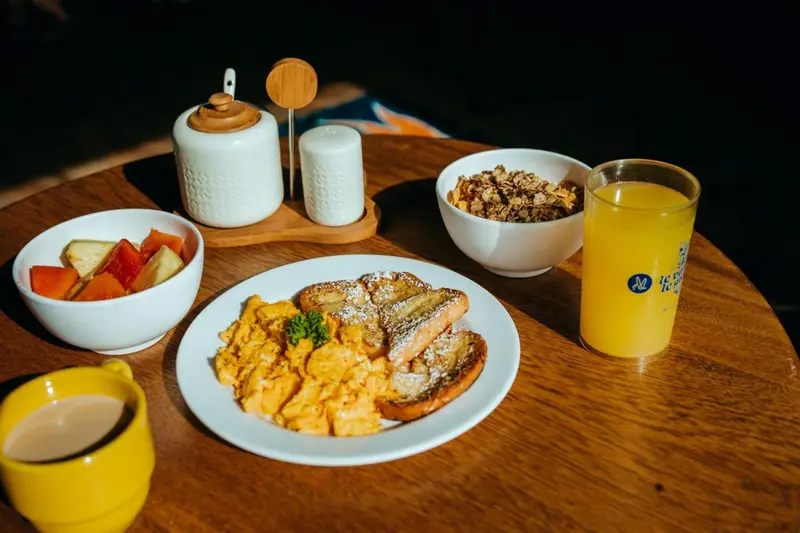Un petit-déjeuner copieux est présenté sur une table en bois.