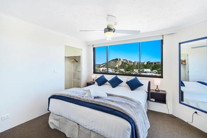 Chambre lumineuse avec un grand lit et vue sur la mer.
