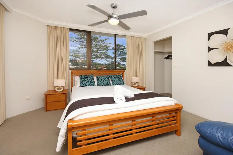 Une chambre lumineuse avec un grand lit et une décoration florale.
