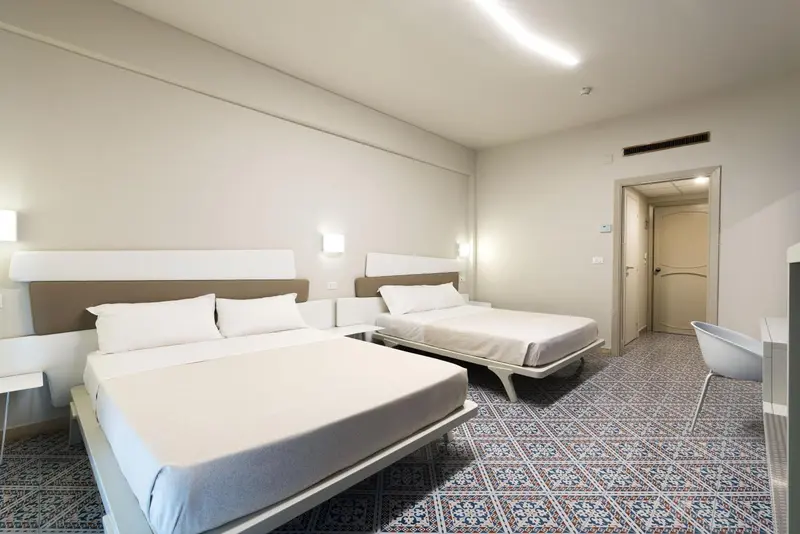 Une chambre lumineuse avec deux lits simples et un bureau.