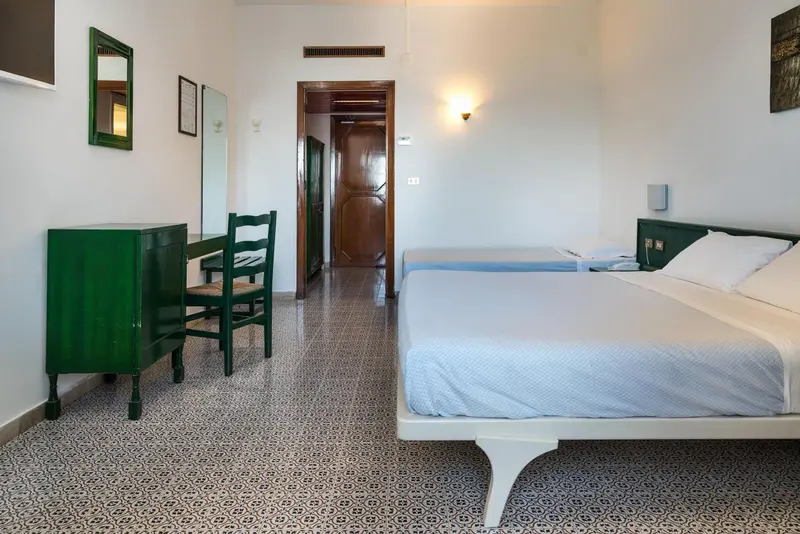 Une chambre lumineuse avec un lit et un coin bureau.