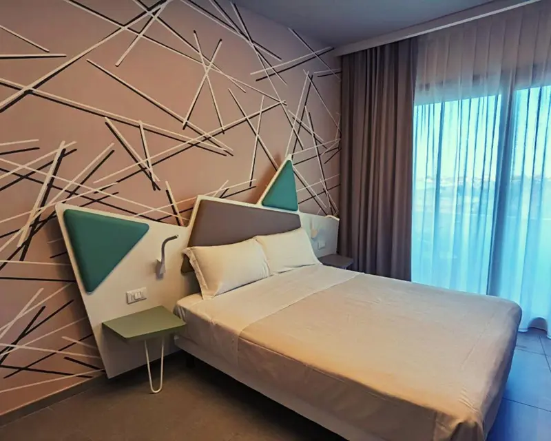 Une chambre moderne avec un lit double et un mur décoratif.