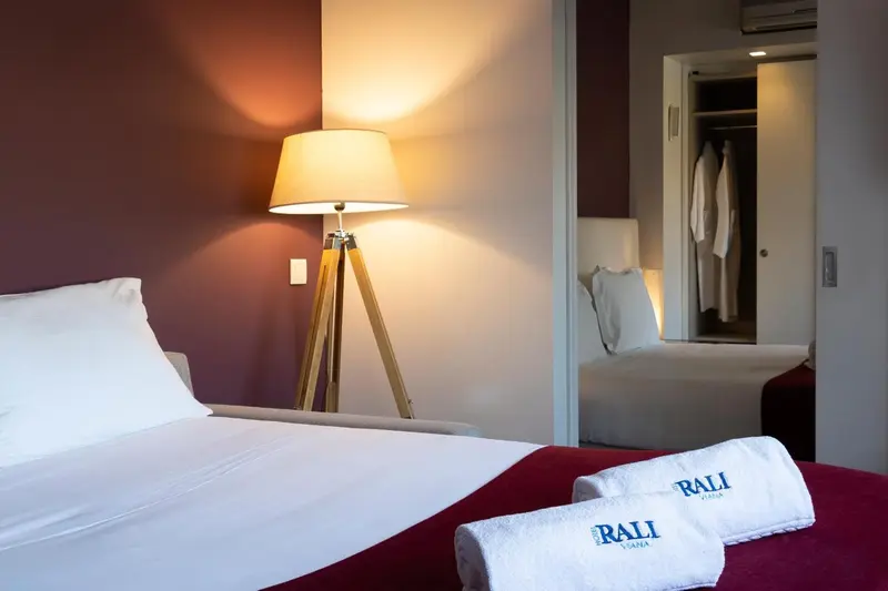 Une chambre lumineuse avec un lit fait et des serviettes soignées.