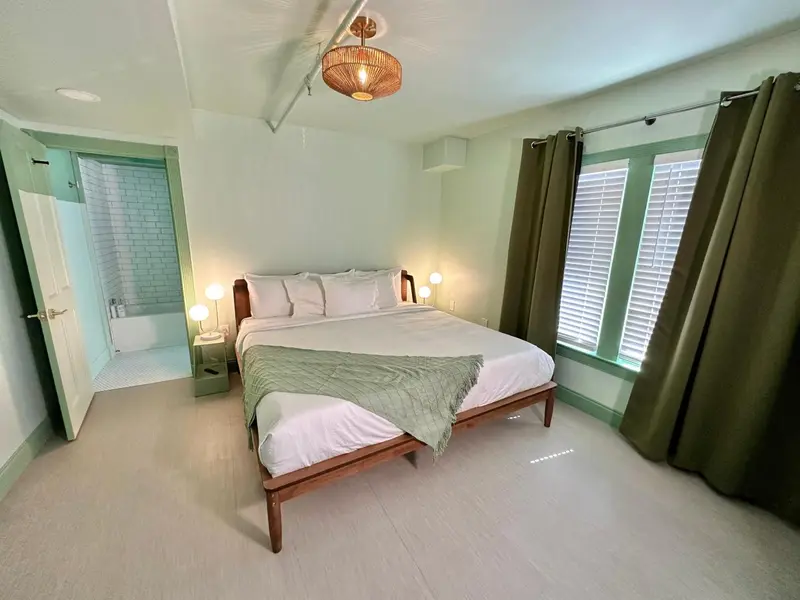 Une chambre lumineuse avec un grand lit et une salle de bain attenante.