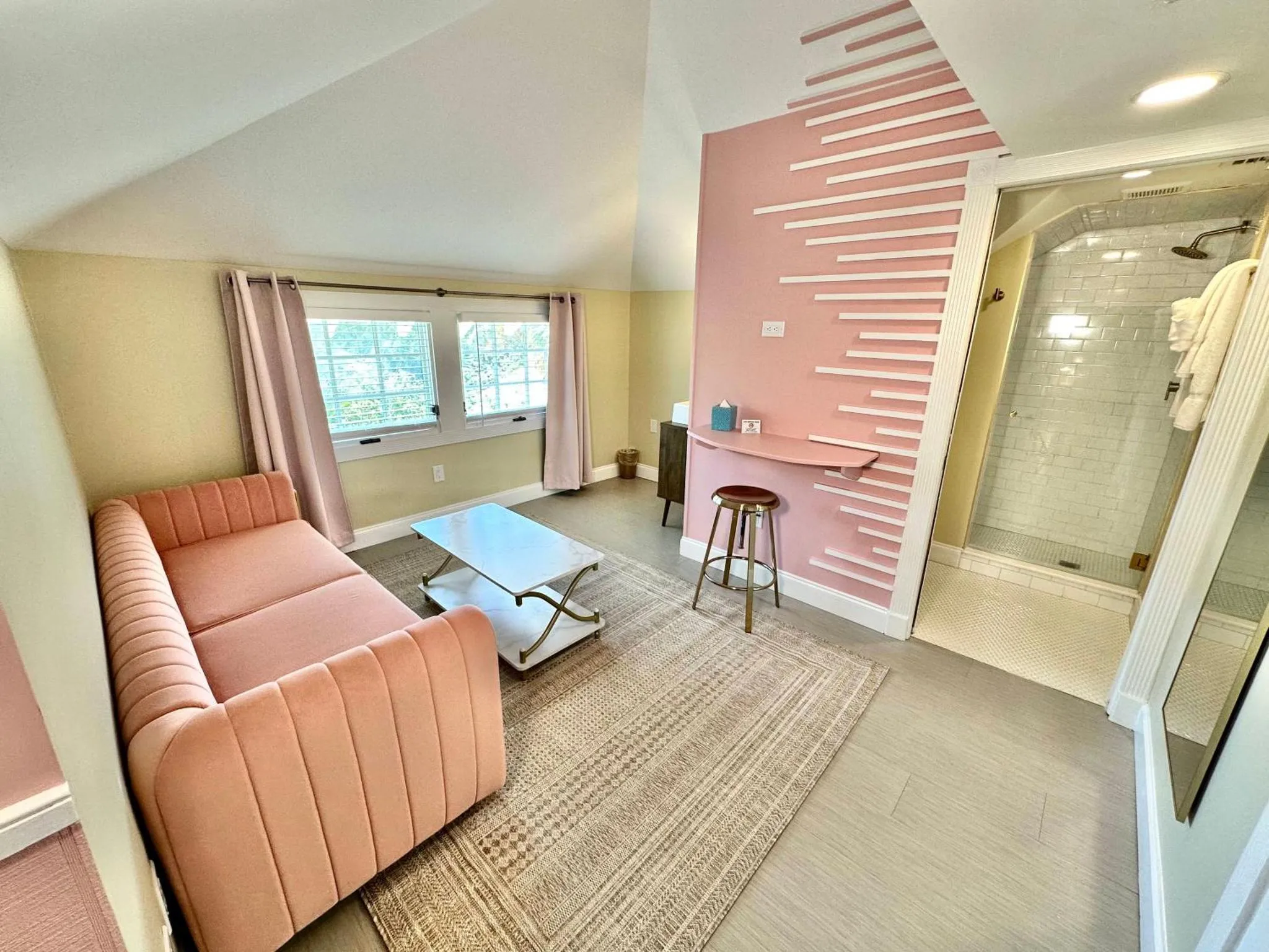 Espace de détente avec canapé rose et bureau intégré.