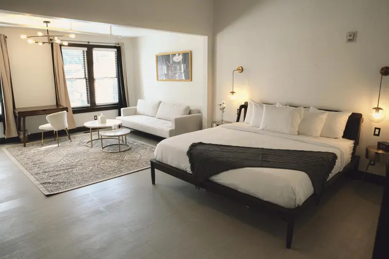 Une chambre lumineuse avec un grand lit et un canapé.
