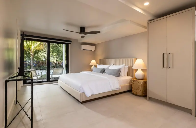 Une chambre lumineuse avec un grand lit et un accès à une terrasse.