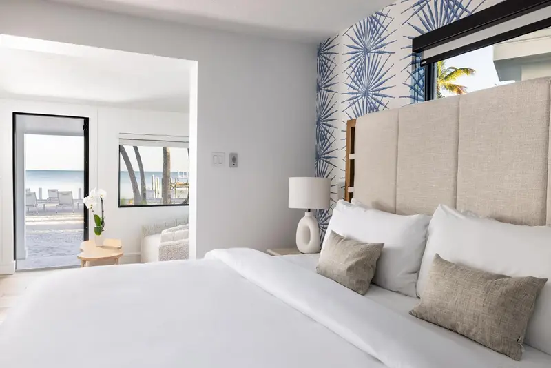 Une chambre lumineuse avec un grand lit et vue sur la mer.