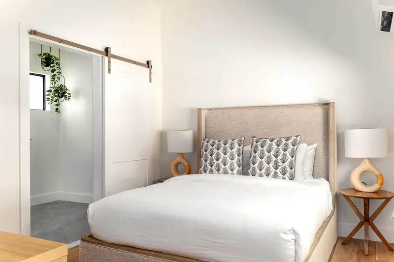 Une chambre lumineuse avec un grand lit et une décoration sobre.