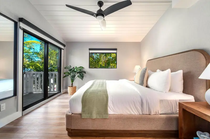 Une chambre lumineuse avec un grand lit et un accès à une terrasse.