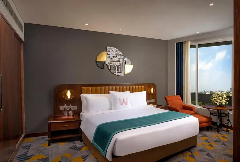 Une chambre d'hotel moderne avec un grand lit et un fauteuil.