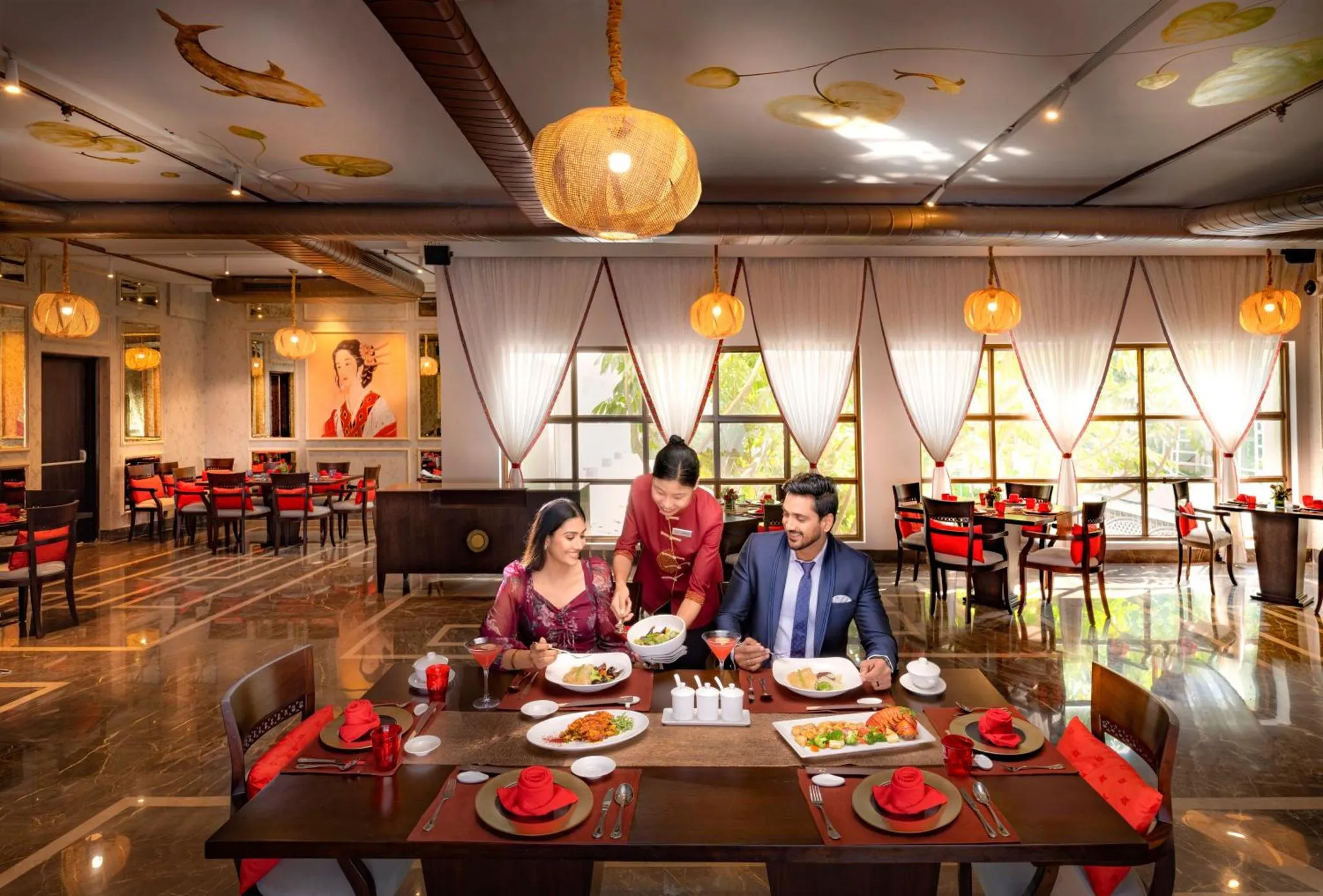 Une salle de restaurant lumineuse avec des tables dressées et des clients servis par du personnel.