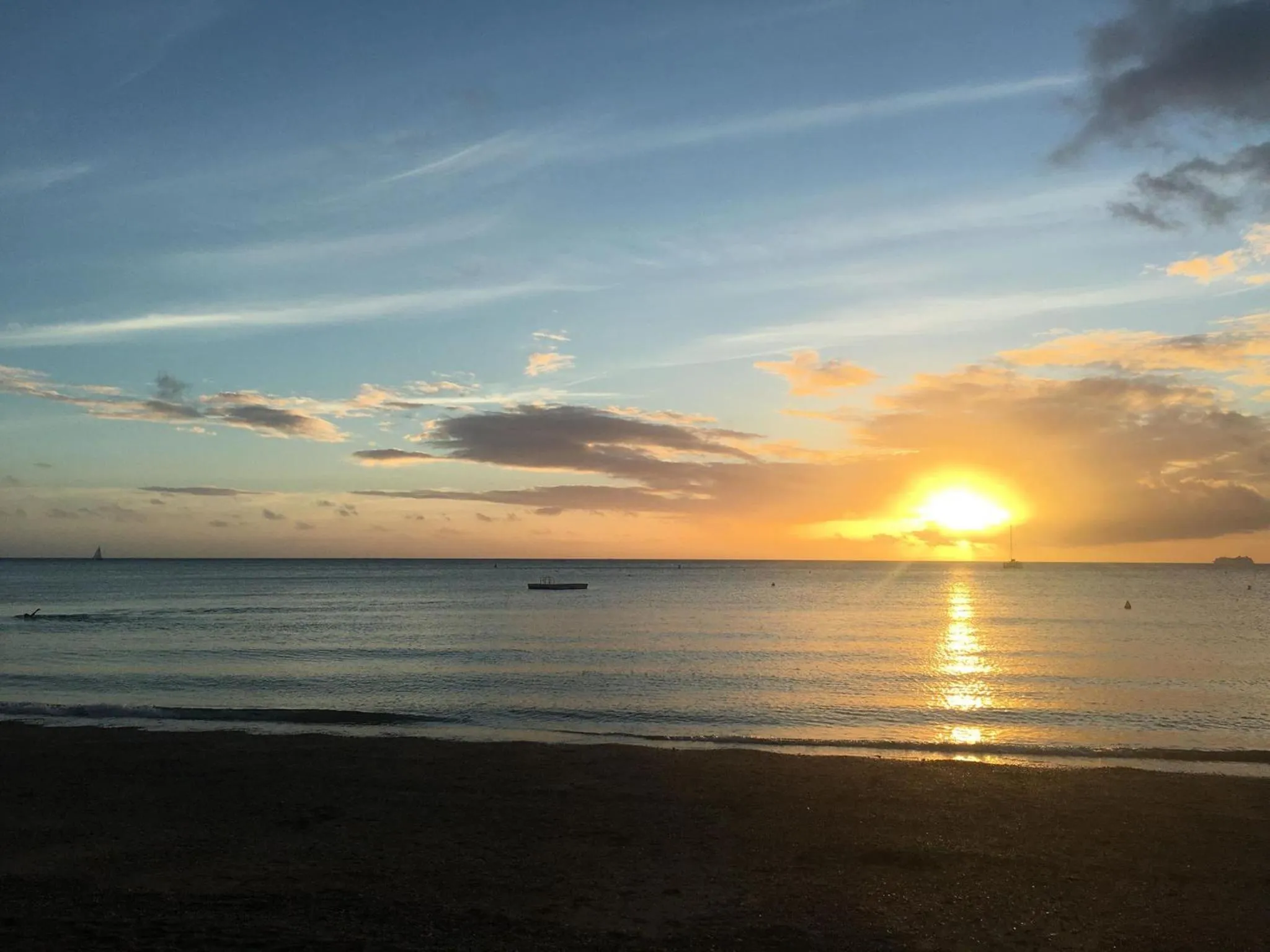 Coucher de soleil sur une plage avec une mer calme.