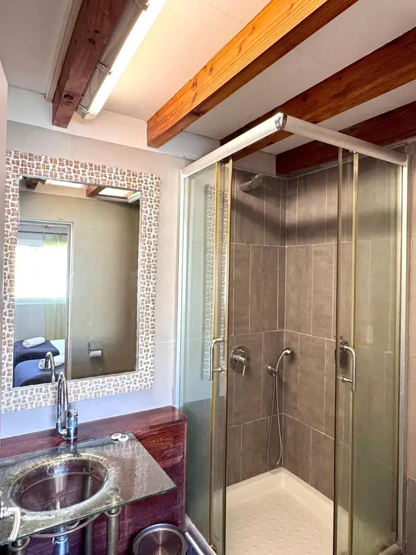 Une salle de bain moderne avec douche à l'italienne et grand miroir.