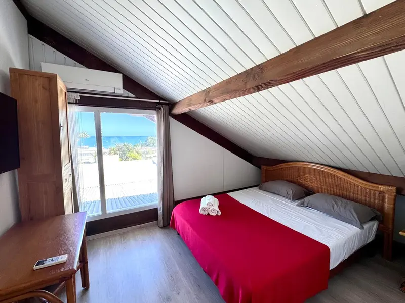 Une chambre lumineuse avec un lit et une vue sur la mer.