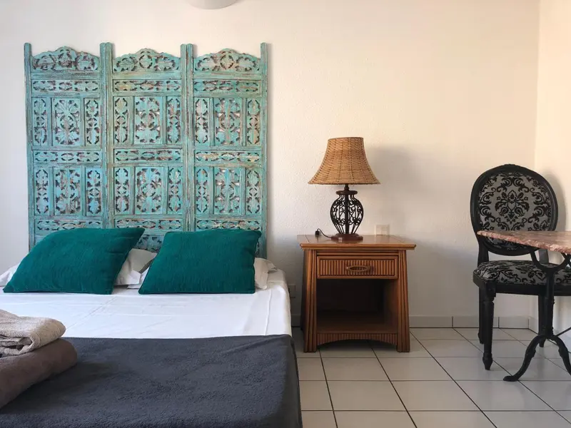 Une chambre lumineuse avec un lit recouvert d'une courtepointe et d'oreillers verts.