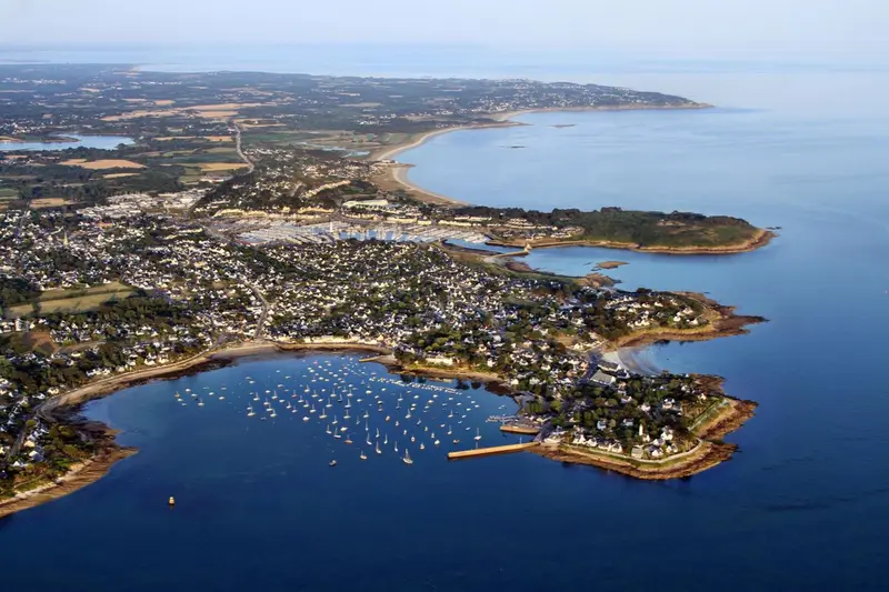 Vue aérienne d'une côte rocheuse avec une ville et un port.