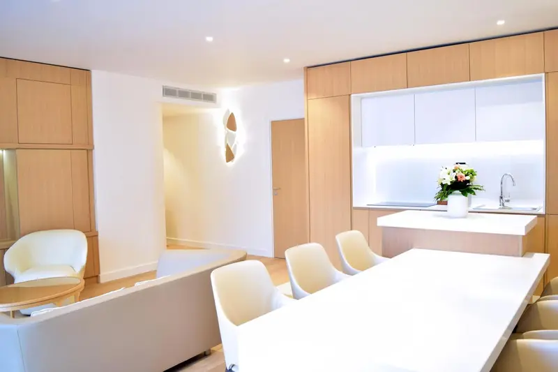 Espace de vie lumineux avec coin repas et canapé blanc.