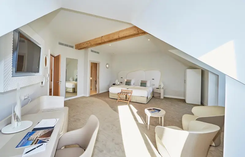 Une chambre lumineuse avec un lit double et un espace détente.