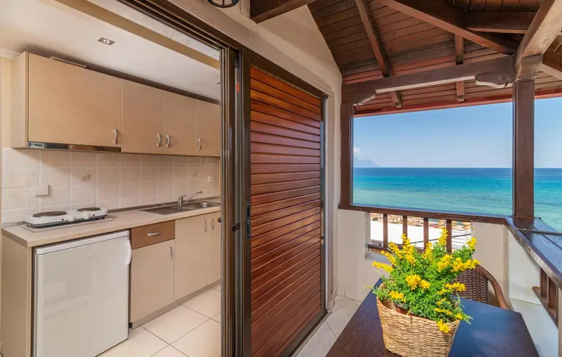 Une cuisine ouverte donne sur une terrasse avec vue sur la mer.