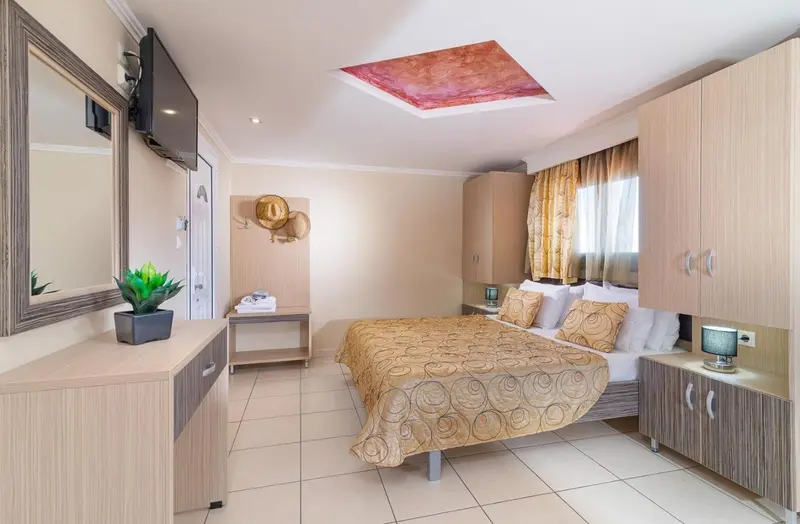 Une chambre lumineuse avec un grand lit et un meuble de télévision.