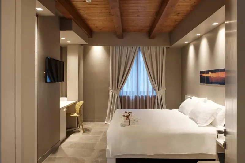 Une chambre lumineuse avec un grand lit et un bureau.