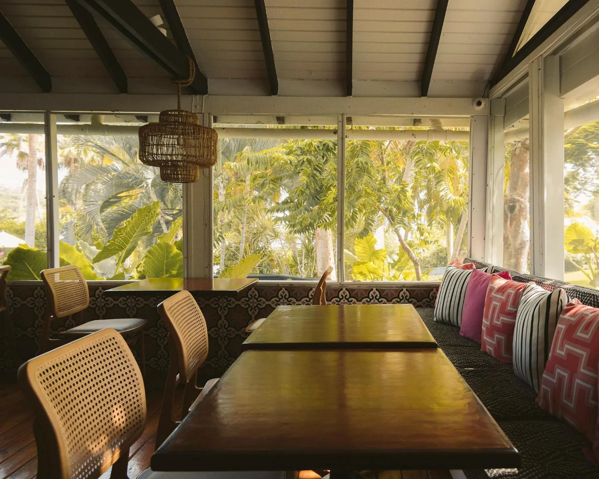 Une salle à manger lumineuse s'ouvre sur une végétation luxuriante.
